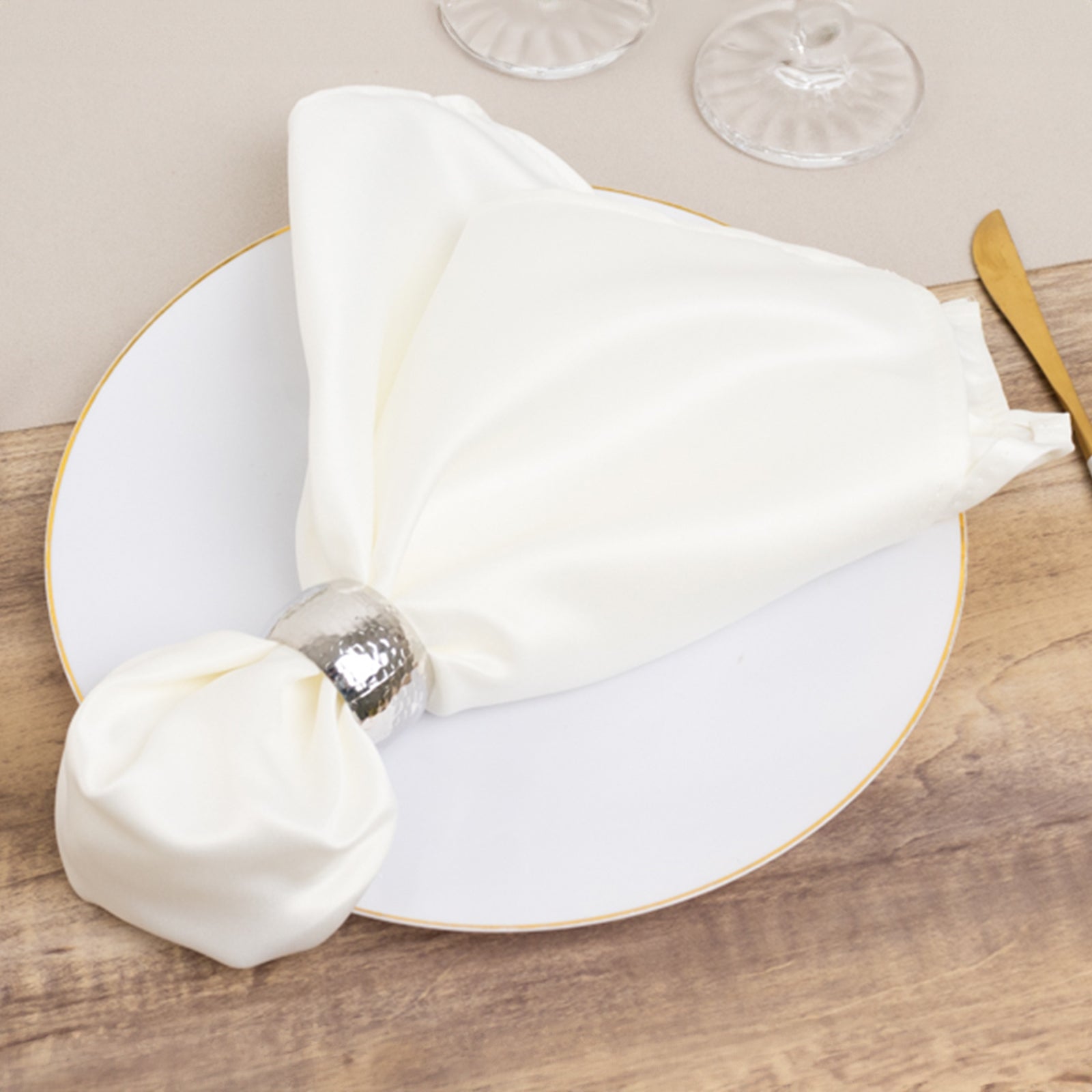 Ivory satin dinner napkins with soft matte finish, elegantly displayed on a plate.