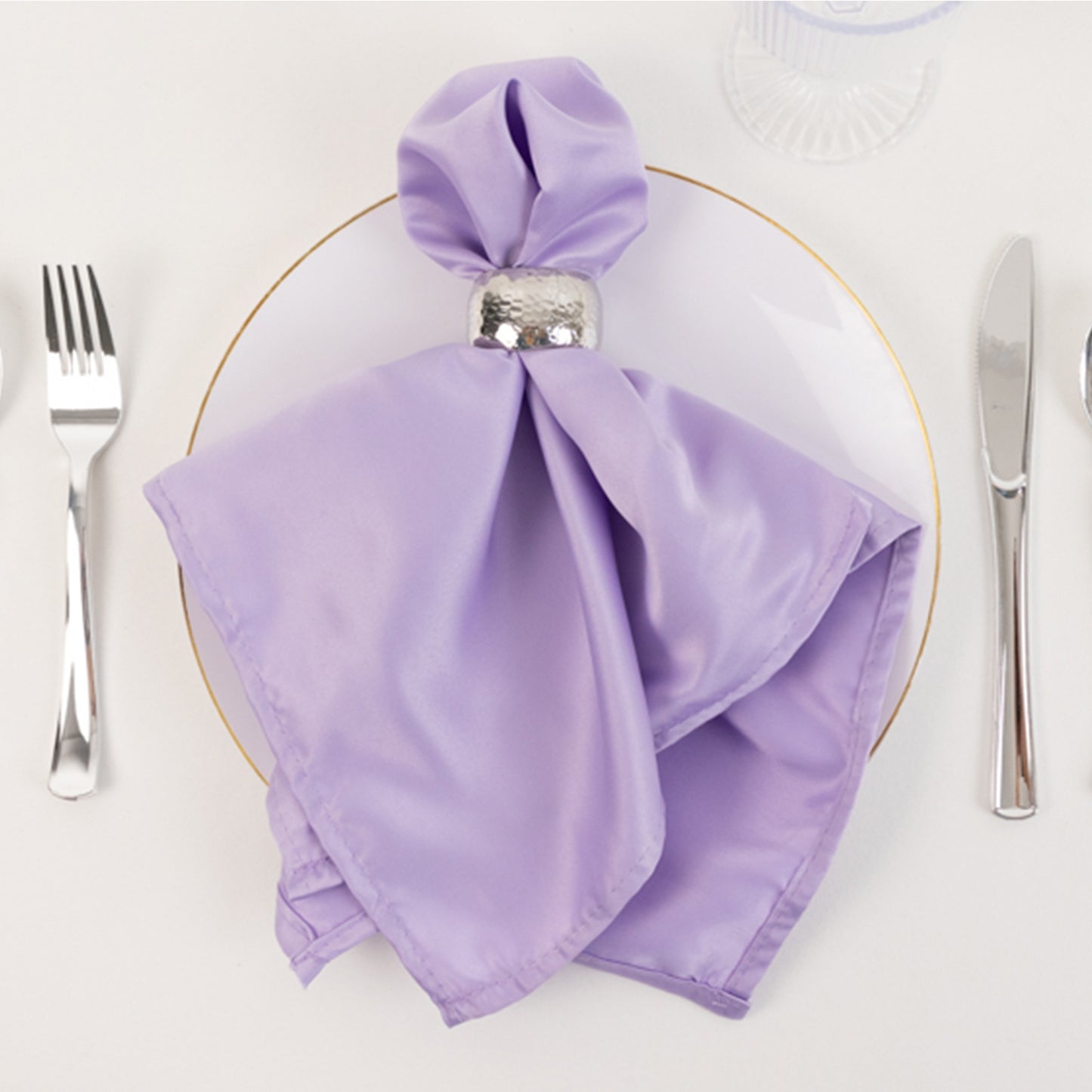 Lavender lilac satin napkin elegantly folded on a plate.