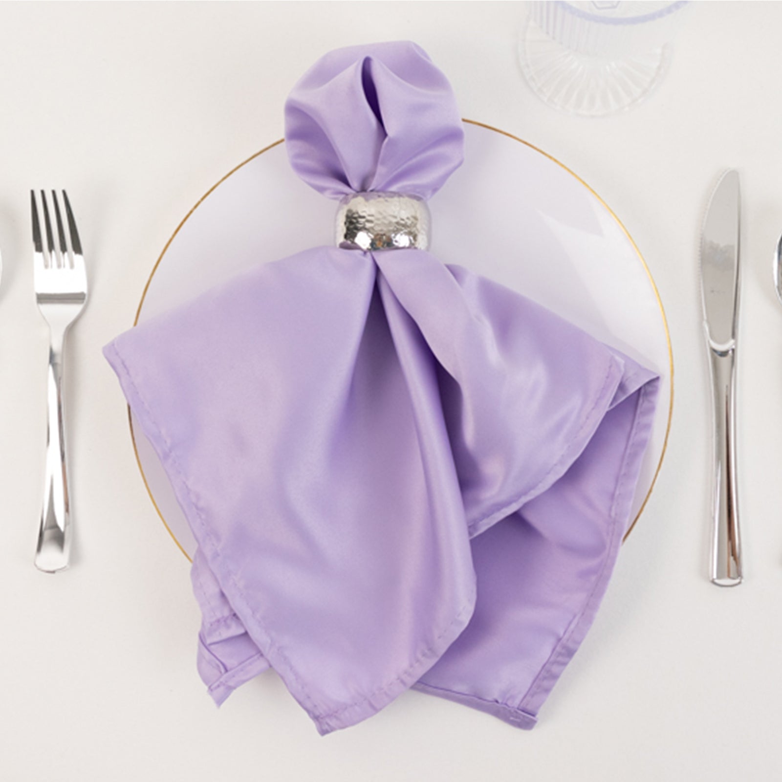 Lavender lilac satin napkin elegantly folded on a plate.