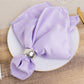 Lavender lilac satin napkin elegantly folded on a dining plate.