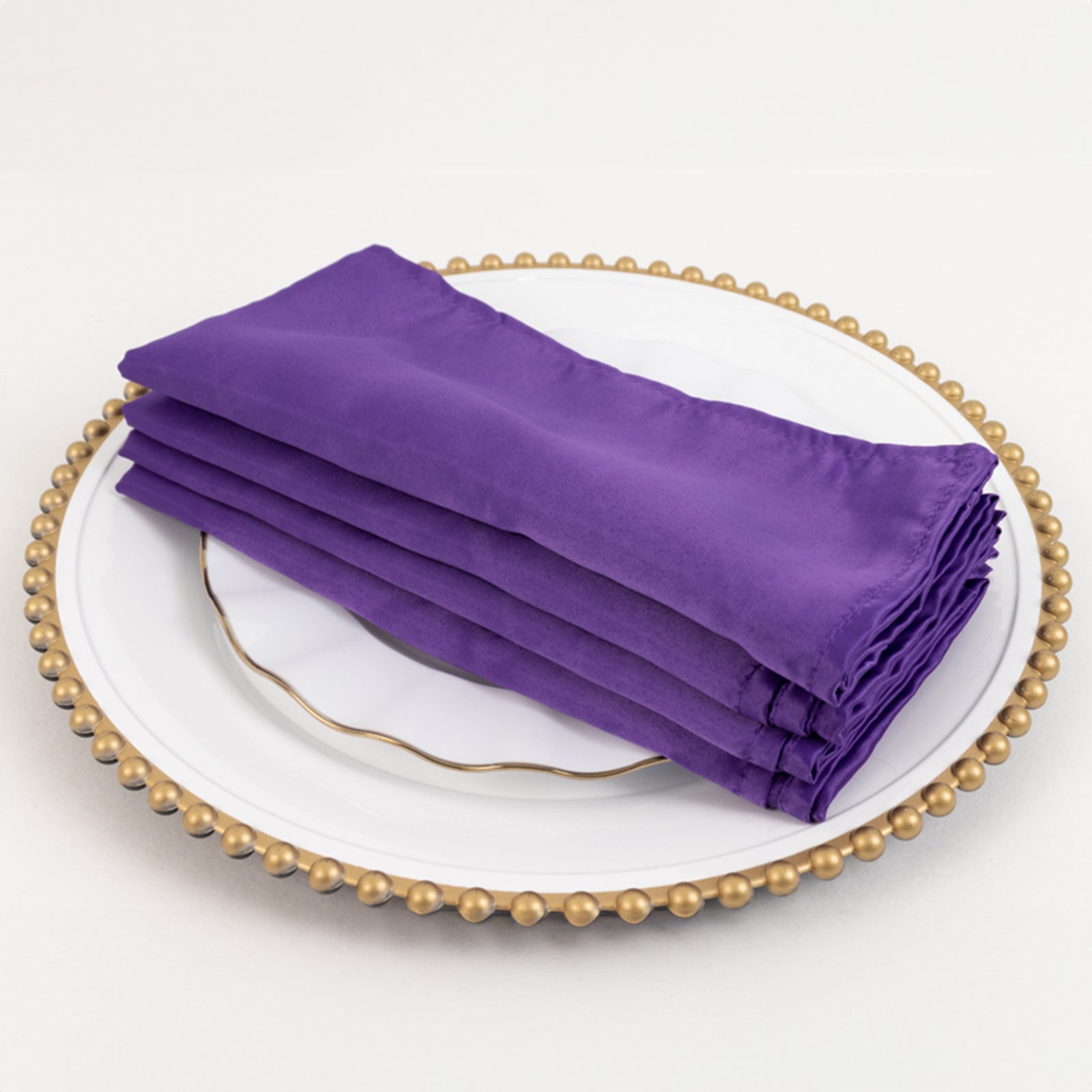 Purple Lamour satin napkins stacked on a decorative plate.