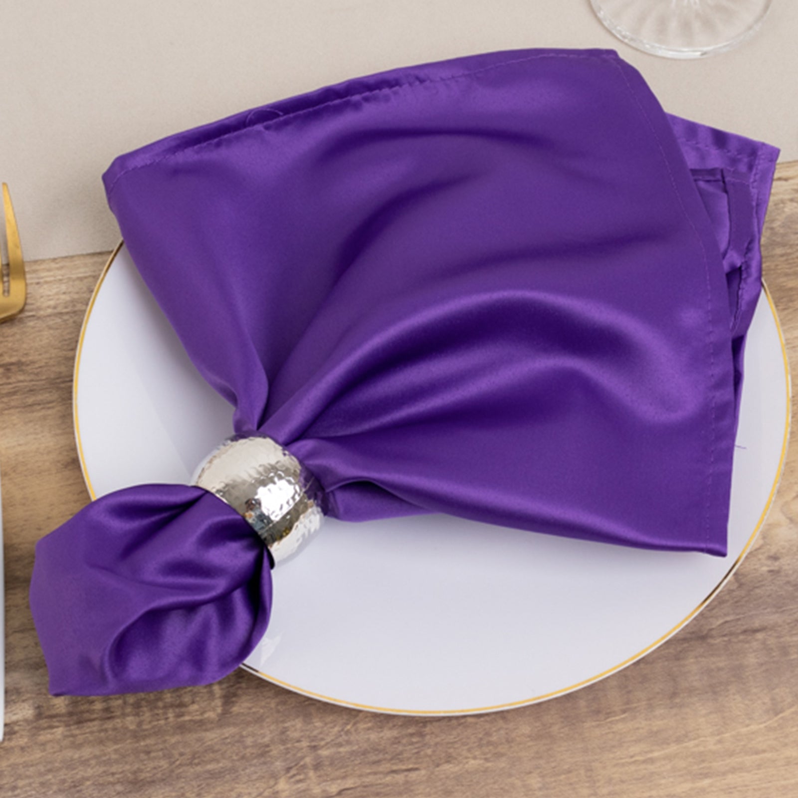 Purple satin napkin elegantly arranged on a plate.