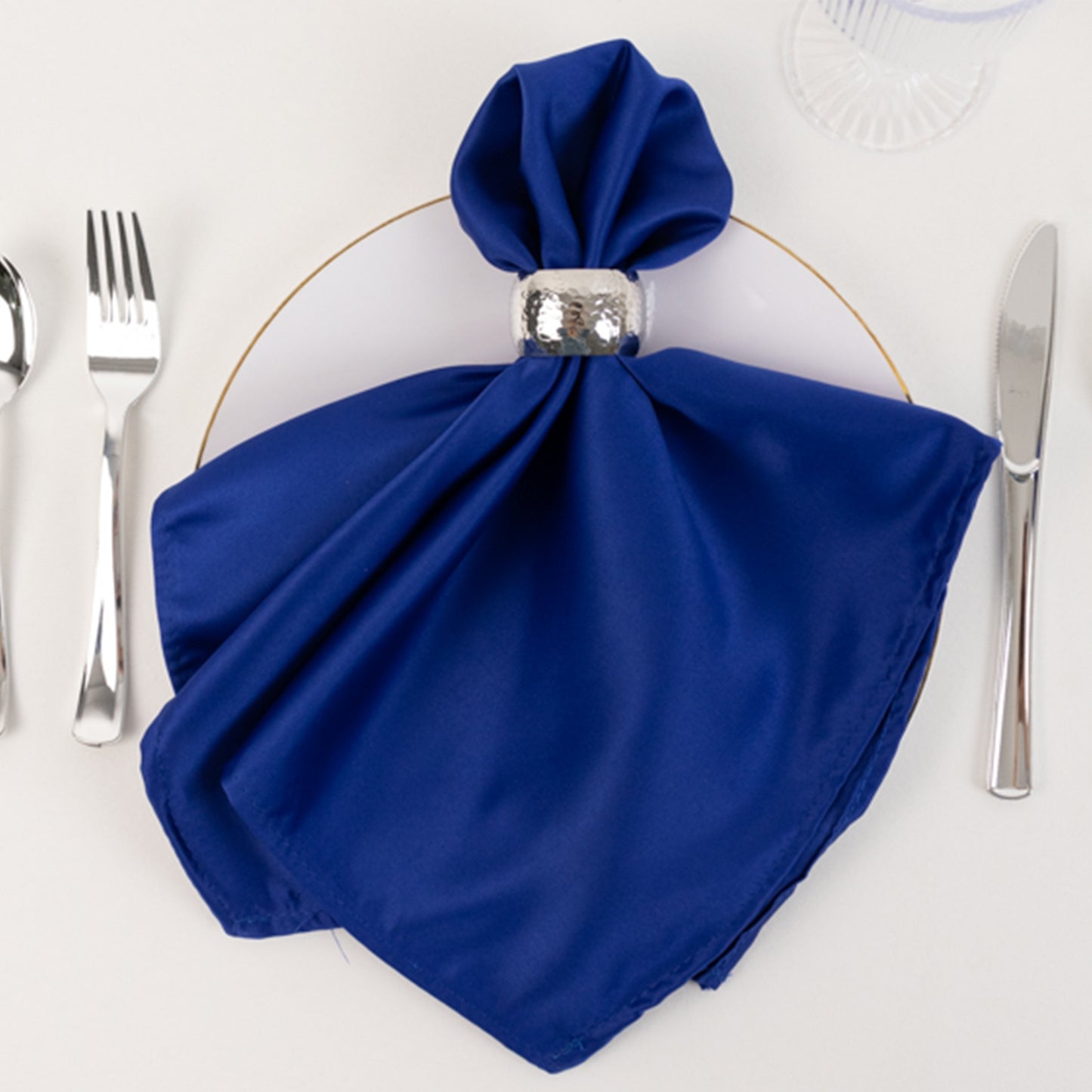 Royal Blue Lamour Satin Napkin on a plate with silver napkin ring.