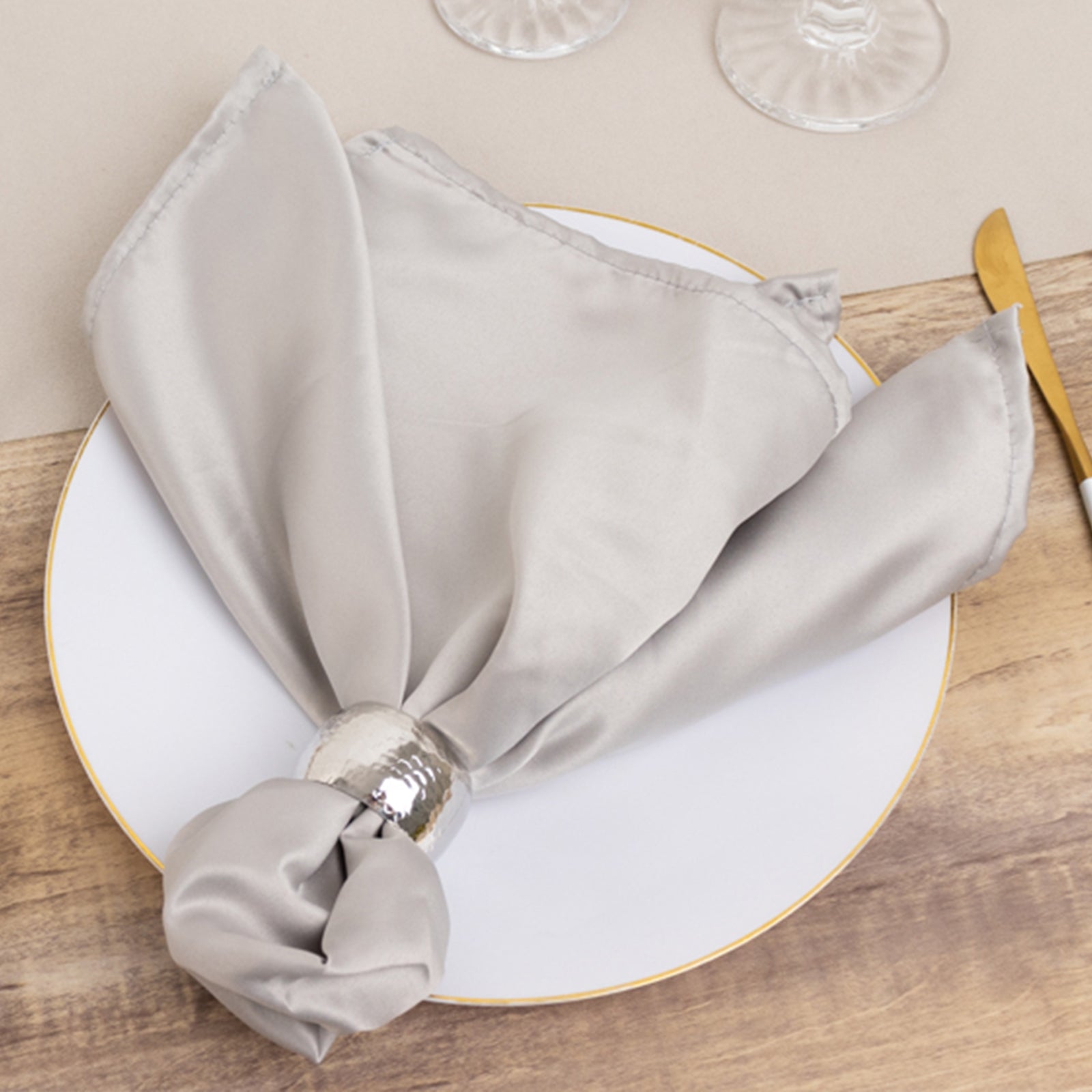 Silver satin napkin elegantly styled on a plate.