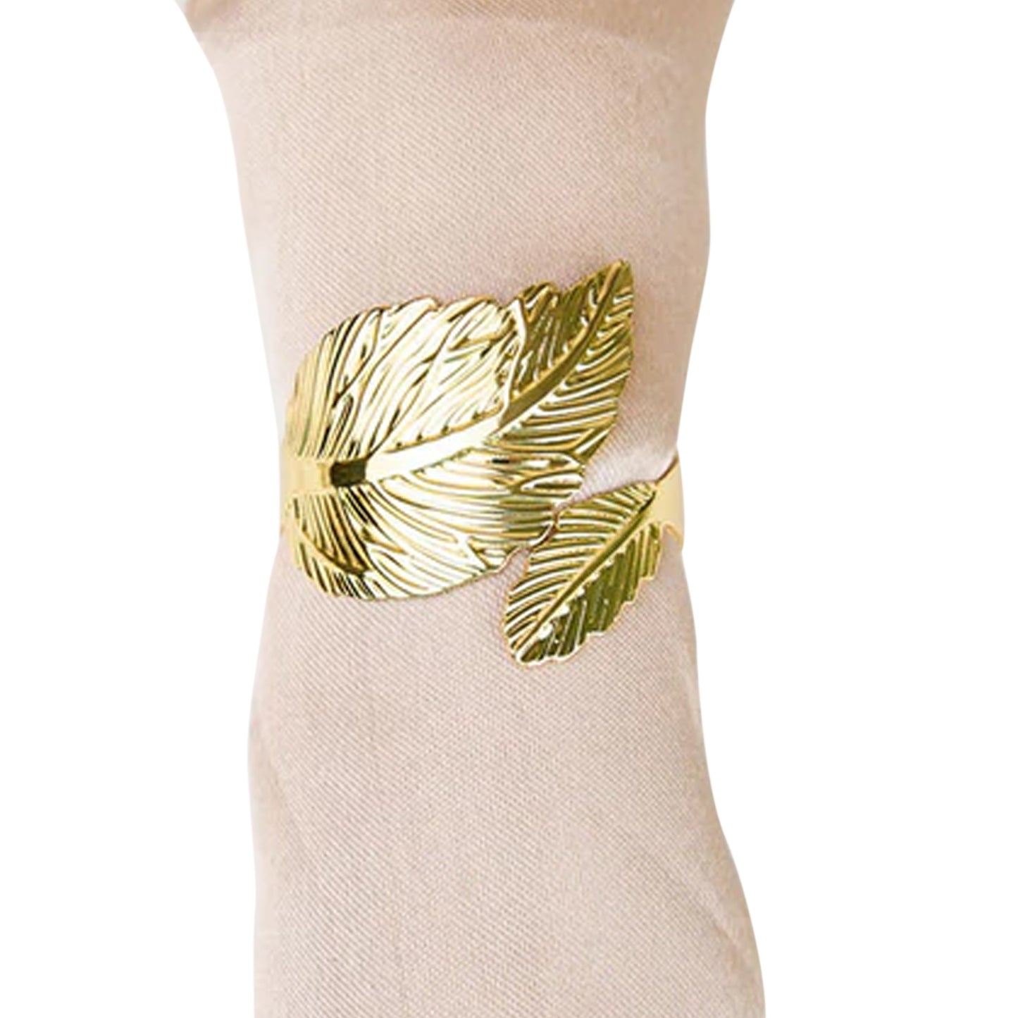 Metallic gold ornate leaf napkin rings on a linen napkin.