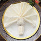 Elegant silver metal floral napkin rings on a cream silk napkin.