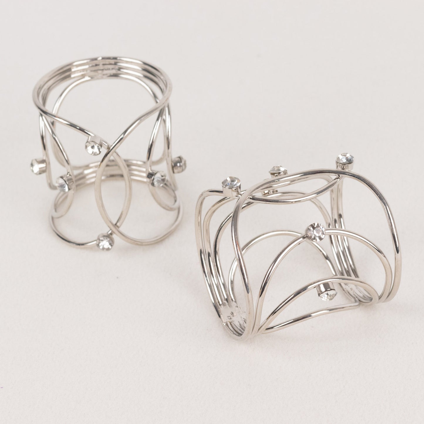 Silver metal napkin rings with rhinestones, elegant woven design.
