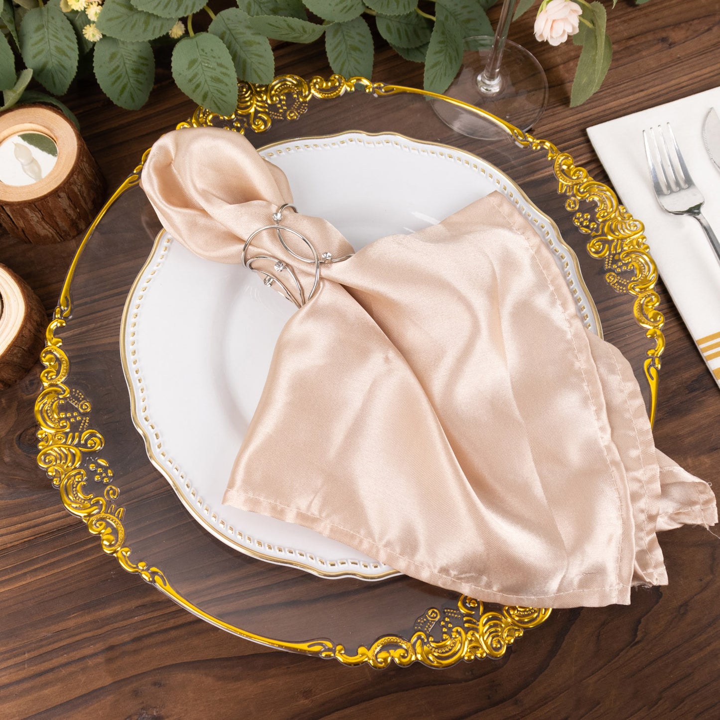 Silver metal napkin rings with rhinestones on a beige napkin.