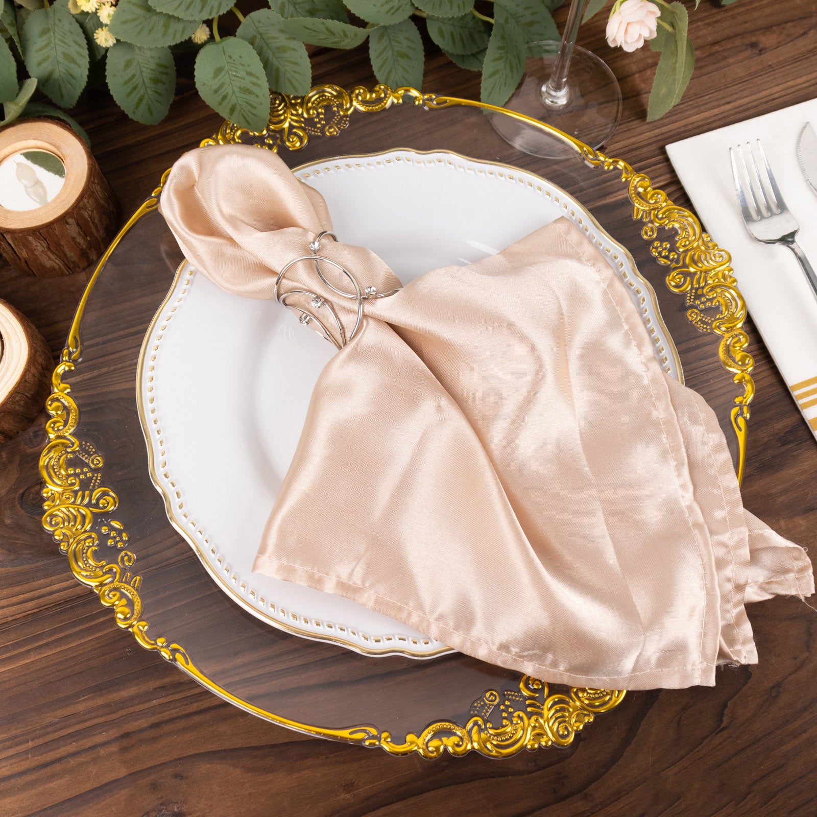 Silver metal napkin rings with rhinestones on a beige napkin.
