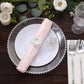 Silver metal hollow sun flower napkin rings on a table setting.