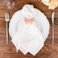 Rose gold butterfly napkin ring on a white napkin and plate.
