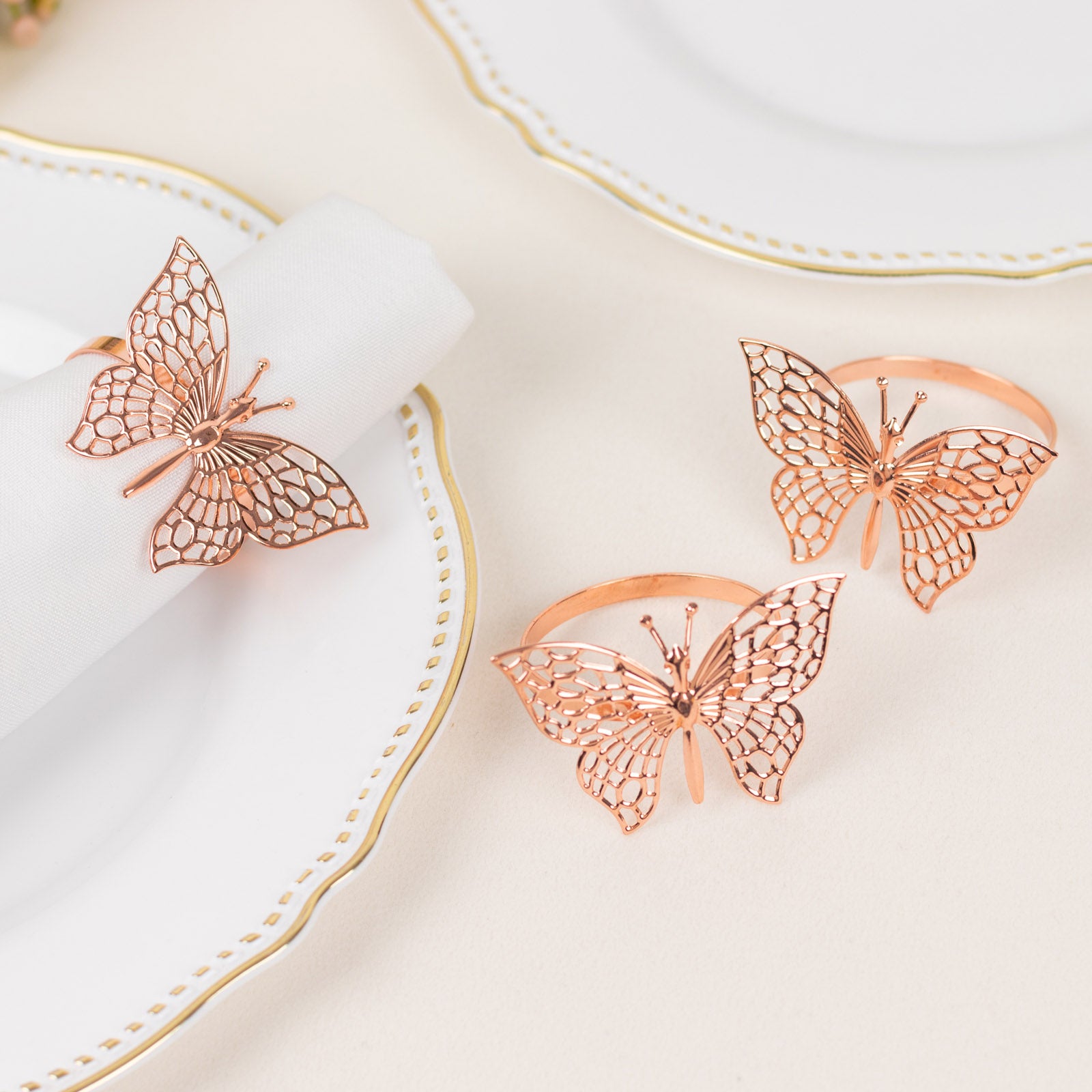 Rose gold butterfly napkin rings for elegant table settings.