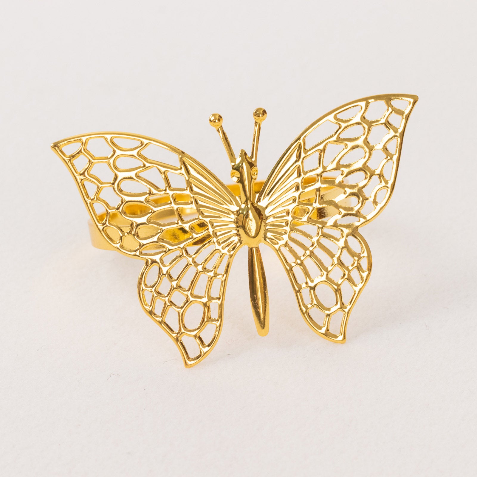 Gold metal butterfly napkin ring, decorative laser cut design.