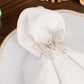 Silver metal butterfly napkin ring on a white cloth napkin.