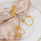 Gold laser cut butterfly metal napkin holders on satin napkins.