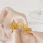 Gold laser cut butterfly napkin holder on beige fabric.