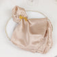 Gold laser cut butterfly napkin holder on a silk napkin, elegant dining table decor.