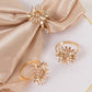 Amber gold floral napkin holders with rhinestone accents.