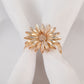 Amber gold floral napkin ring with rhinestone accents on a white napkin.