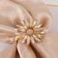 Amber gold floral napkin holder with rhinestone accents on a satin napkin.