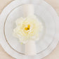 Ivory floral napkin holder with silk peony flower on a dining plate.