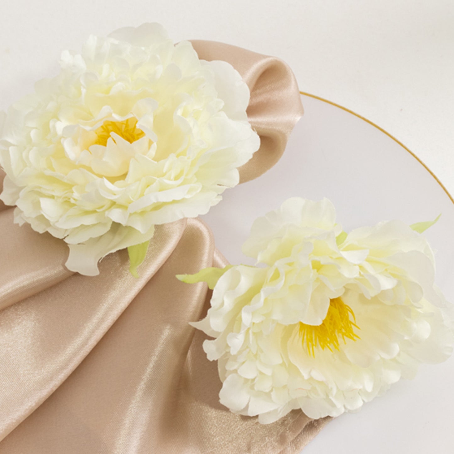 Ivory floral napkin holders with silk peony flowers for dining table settings.