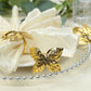 Glossy gold metal leaf napkin rings with vintage herb design.