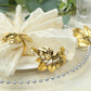 Glossy gold metal leaf napkin rings with vintage herb design.