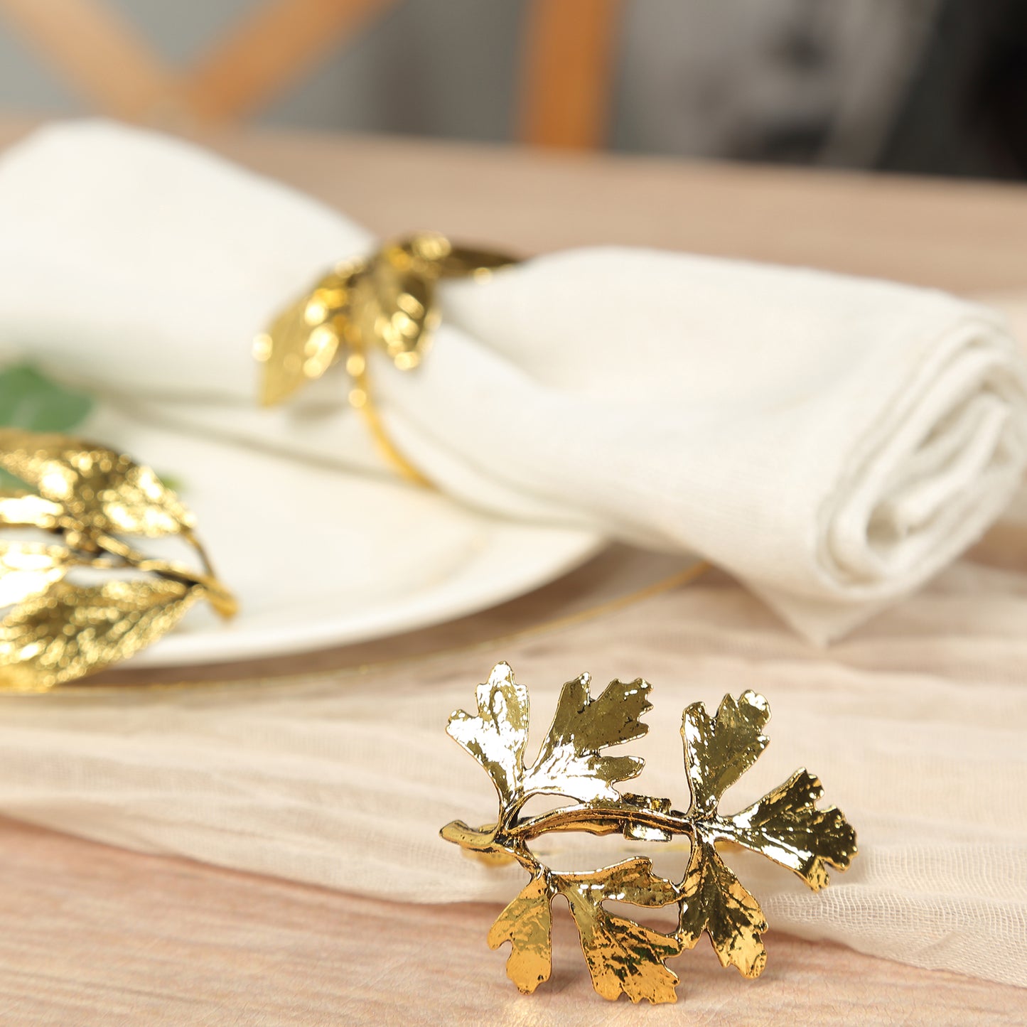 Glossy gold metal leaf napkin rings for vintage table settings.