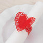 Red shimmery laser cut heart paper napkin holder with lace pattern.