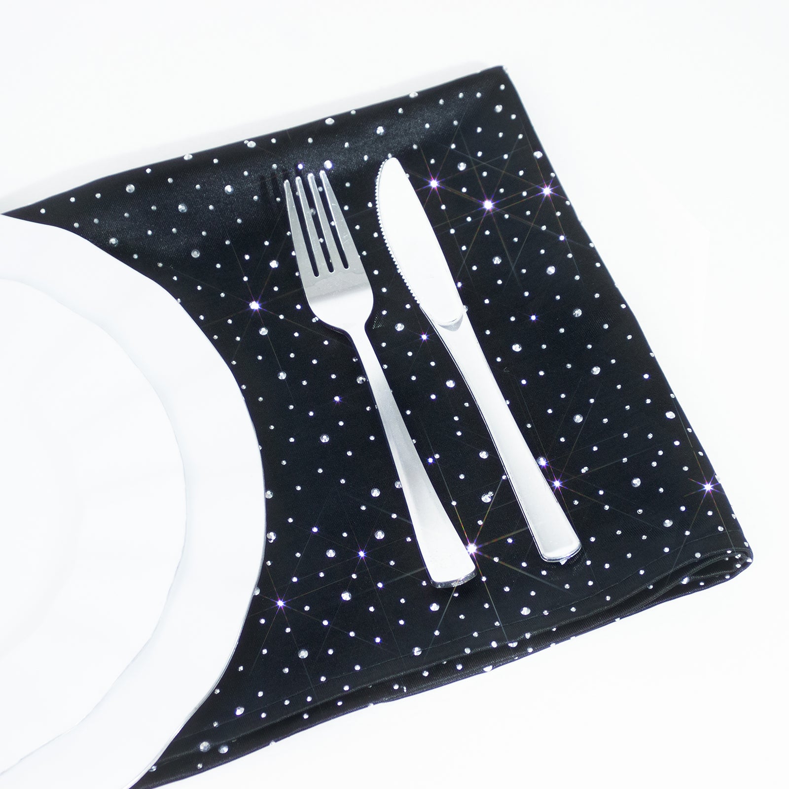 Black scuba polyester napkin with rhinestone accents on a white plate.