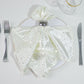 Pearl white reusable napkin with rhinestone accents on a plate setting.