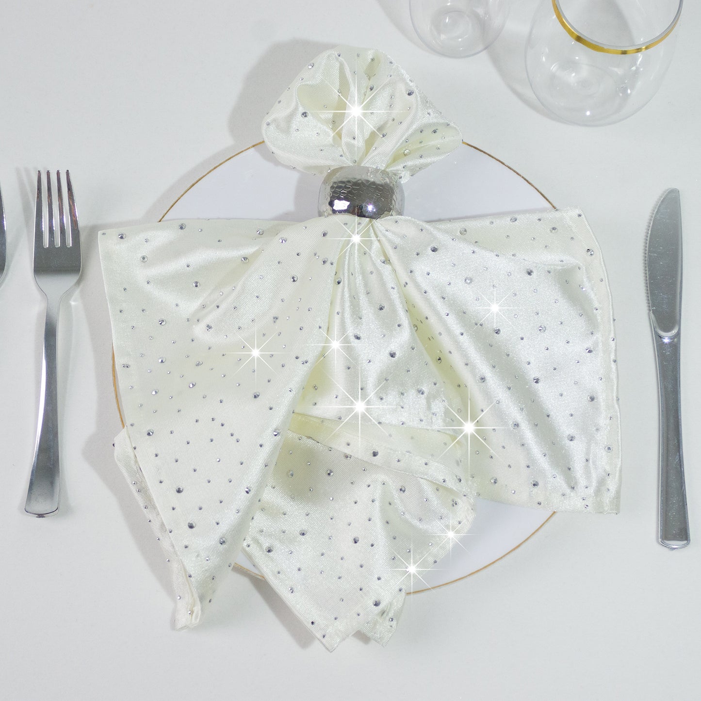 Pearl white reusable napkin with rhinestone accents on a plate setting.