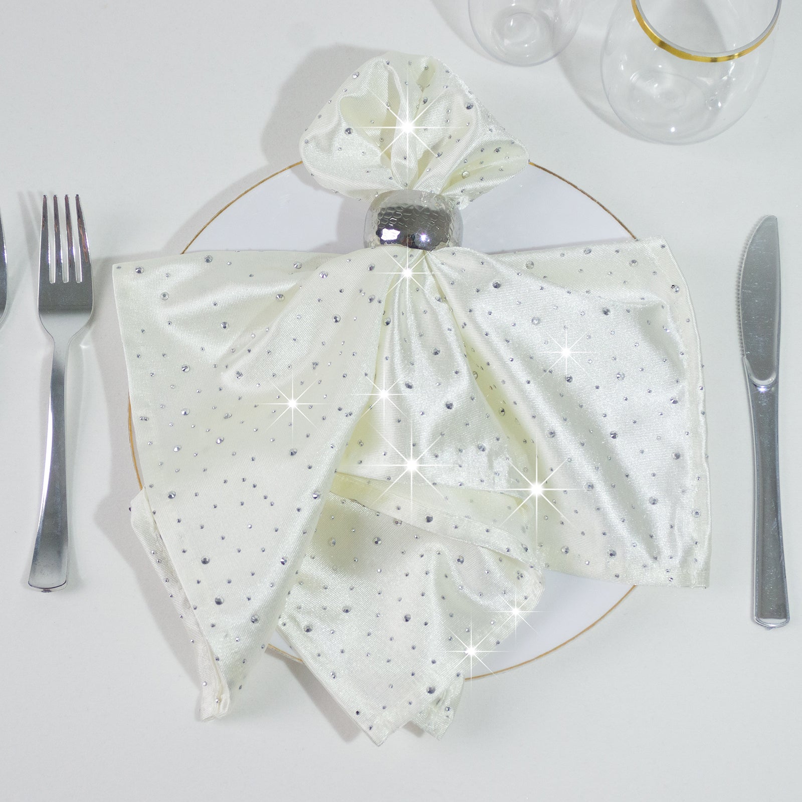Pearl white reusable napkin with rhinestone accents on a plate setting.