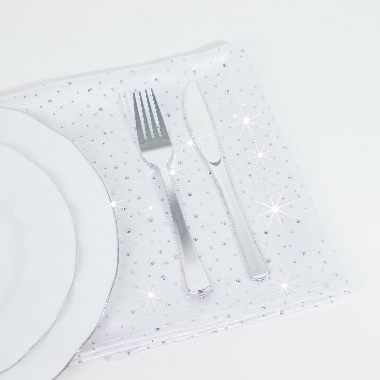 White scuba polyester napkin with rhinestone accents on a table setting.