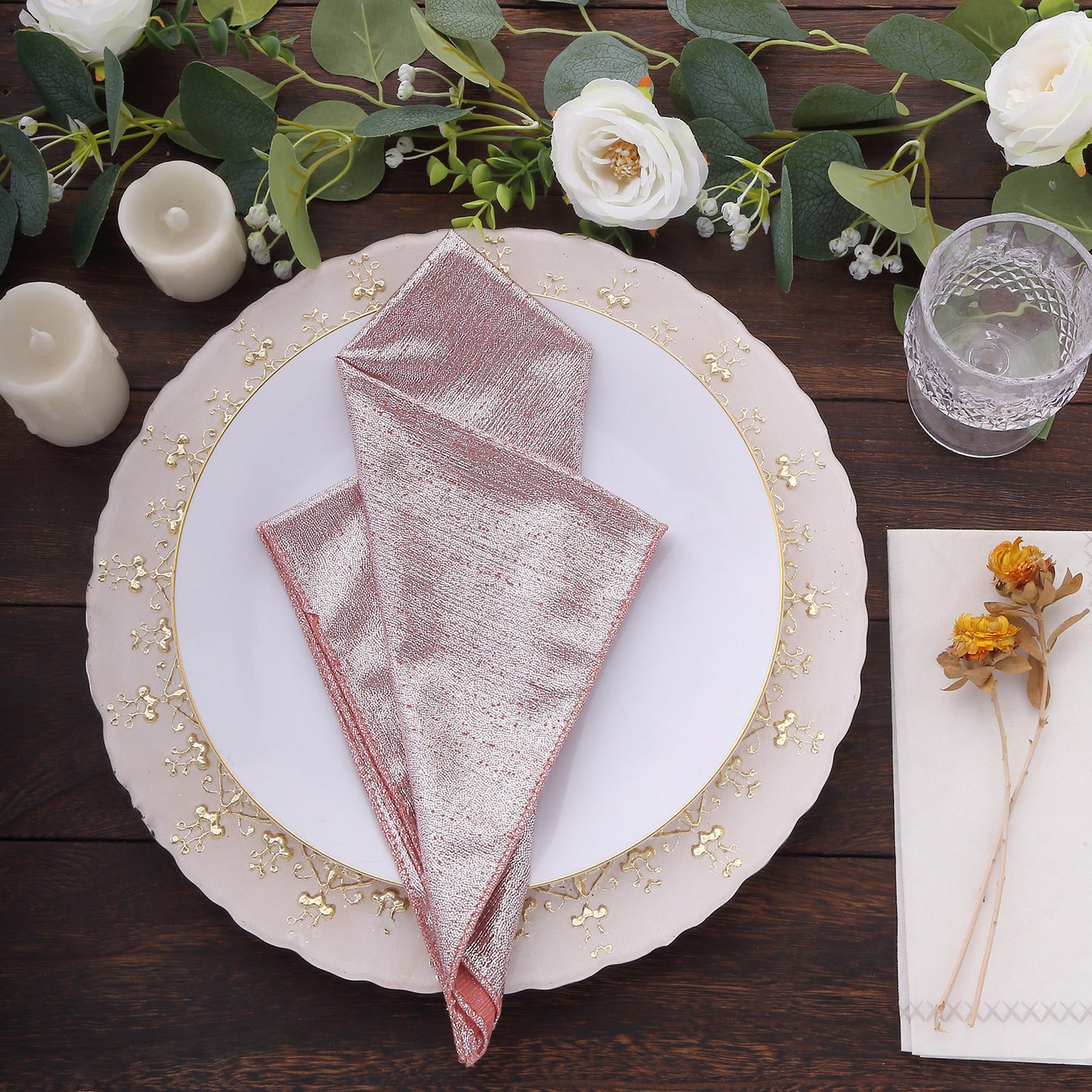 Rose gold shimmer sequin table napkins on a decorative plate.
