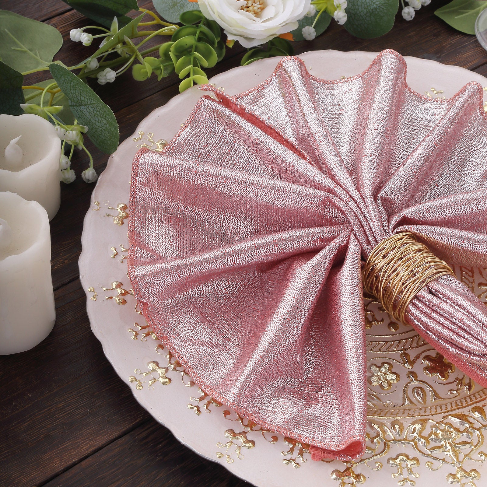 Rose gold shimmer sequin dinner napkins on a decorative plate.