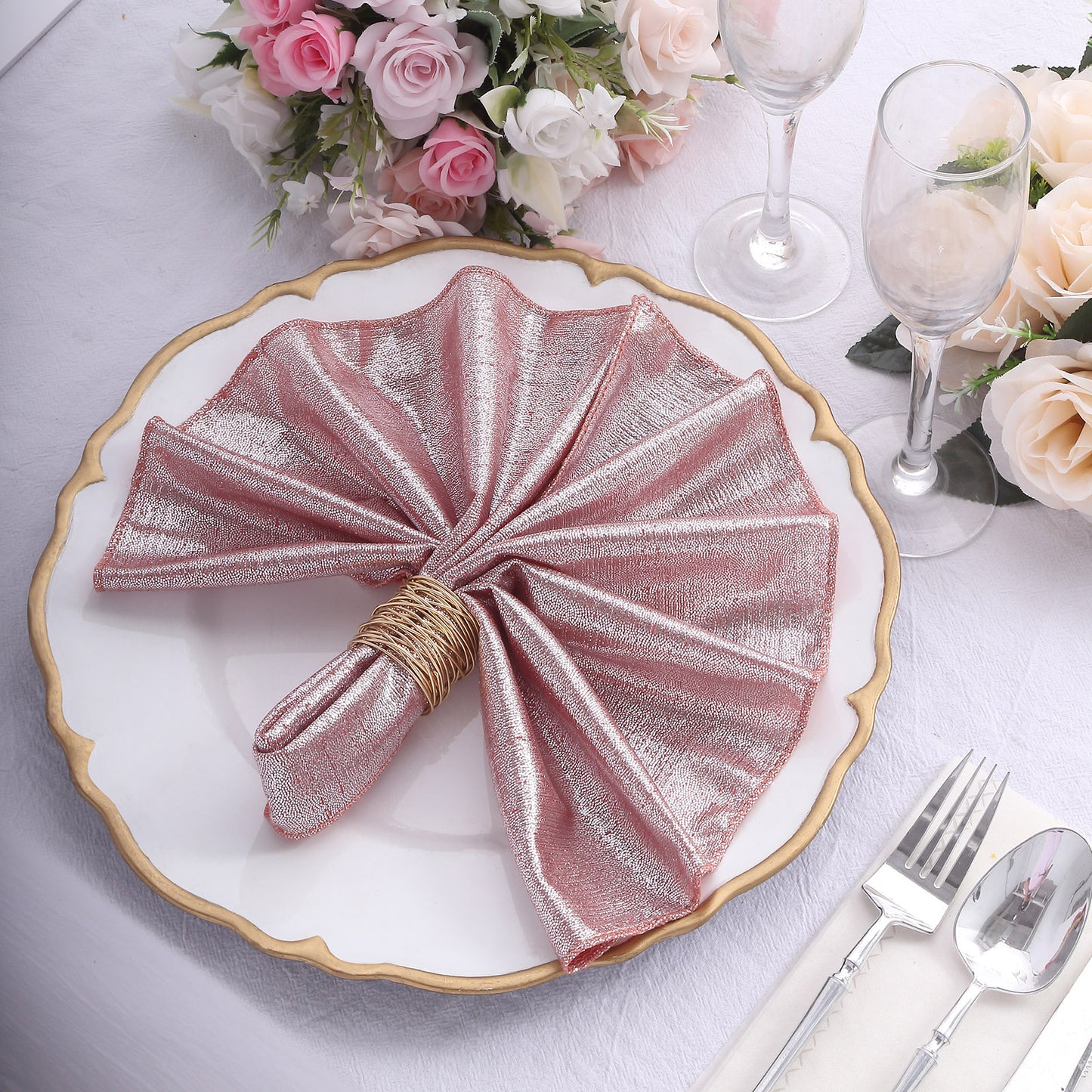 Rose gold shimmer sequin table napkin on a decorative plate.