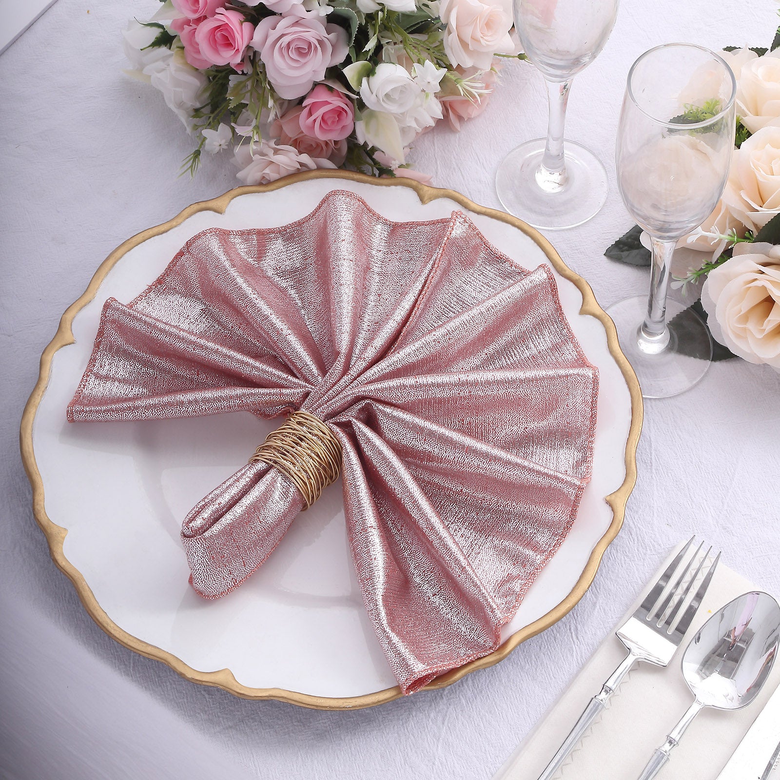 Rose gold shimmer sequin table napkin on a decorative plate.