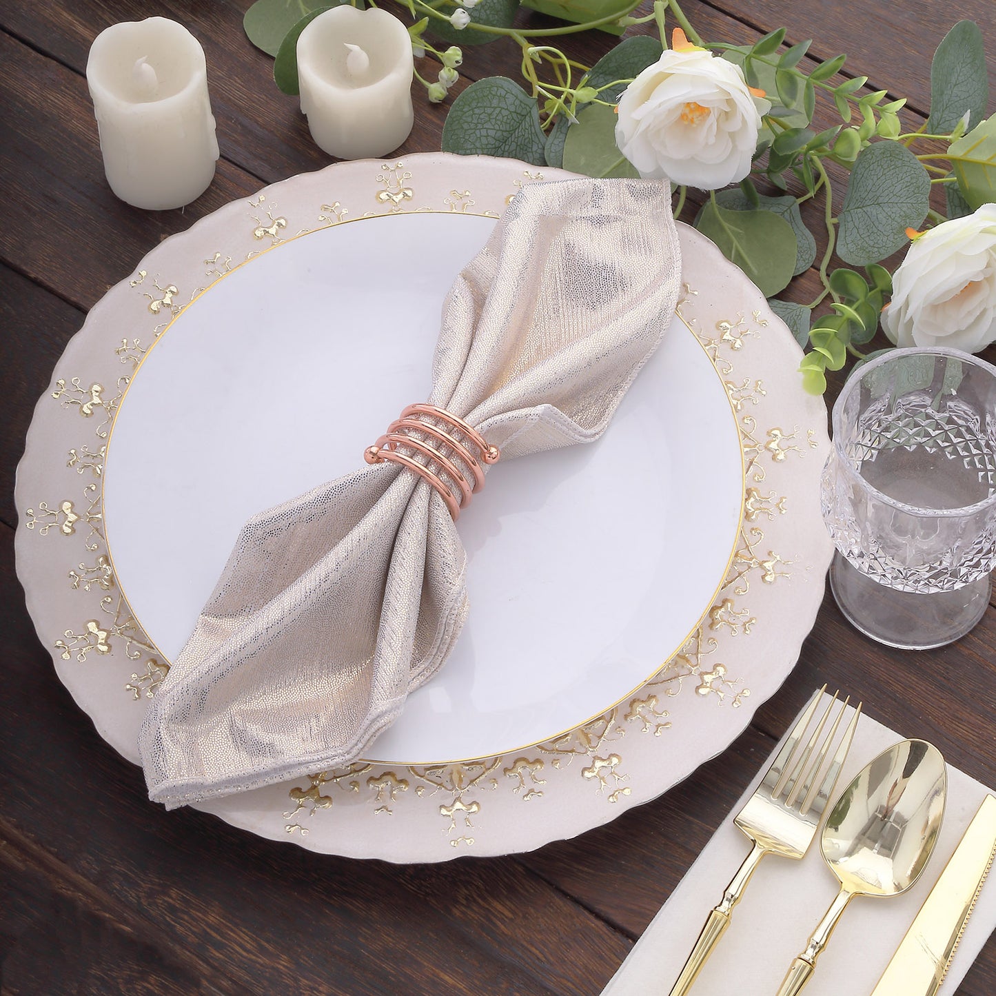Beige shimmer sequin napkin on a white plate with gold trim and floral decor.