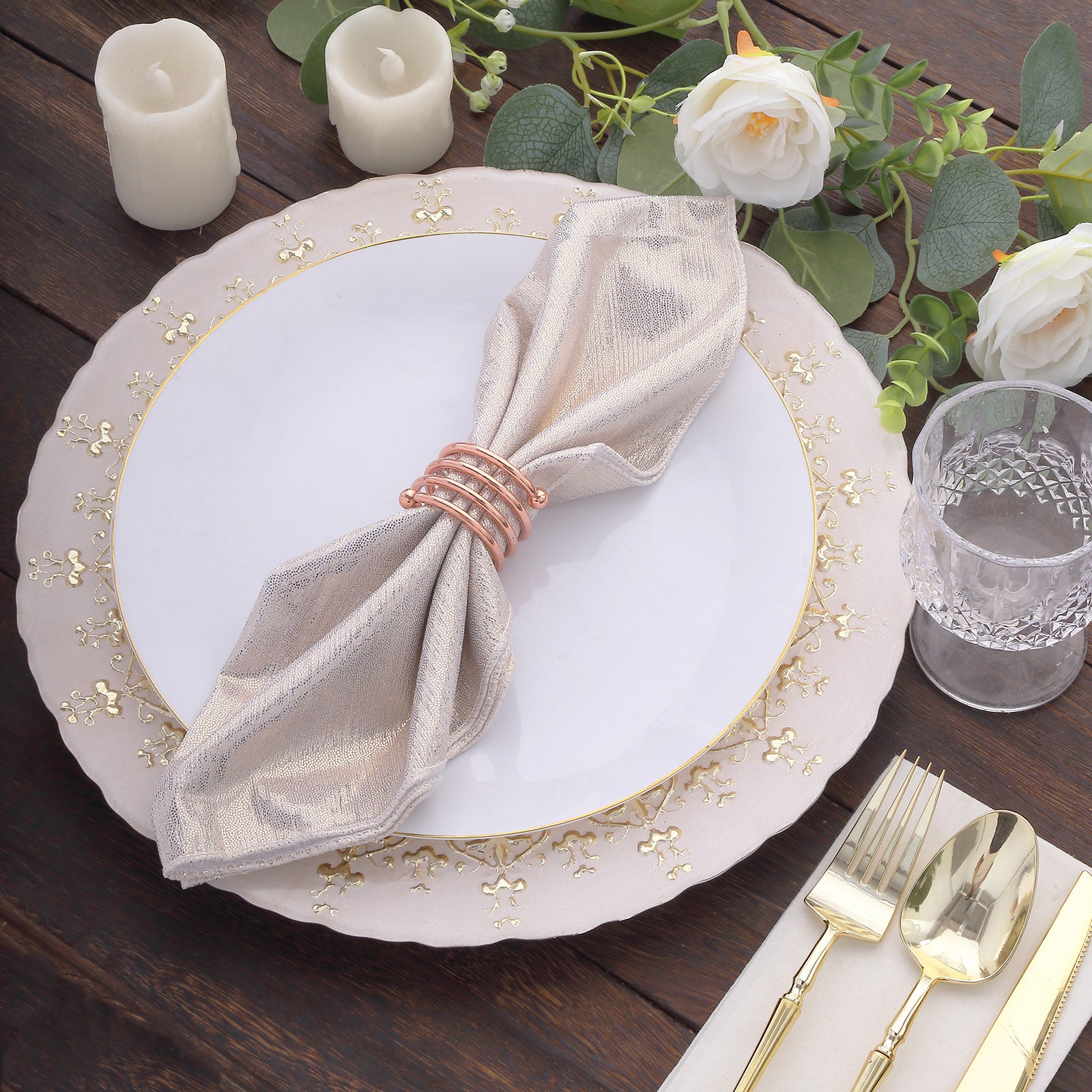 Beige shimmer sequin napkin on a white plate with gold trim and floral decor.