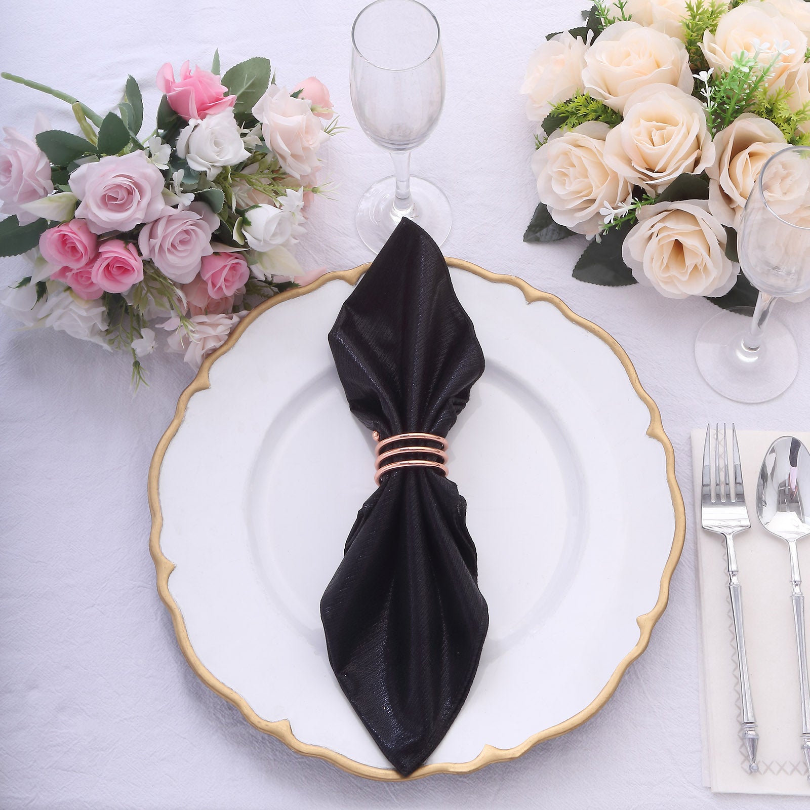 Black shimmer sequin table napkin on a white plate with floral decor.