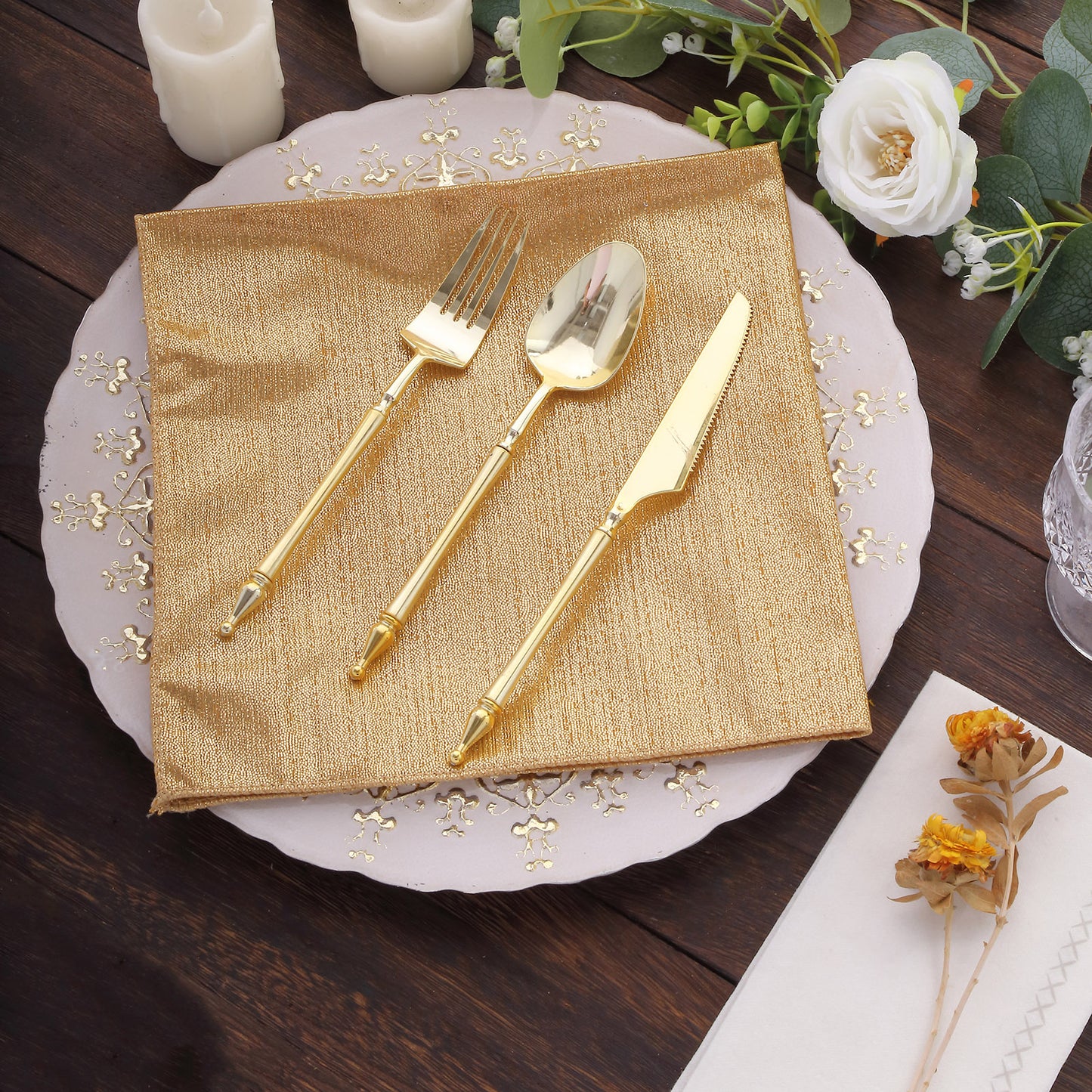 Gold shimmer sequin dots napkin on a table setting with golden utensils.