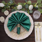 Emerald green shimmer sequin table napkin on an elegant dinner plate.