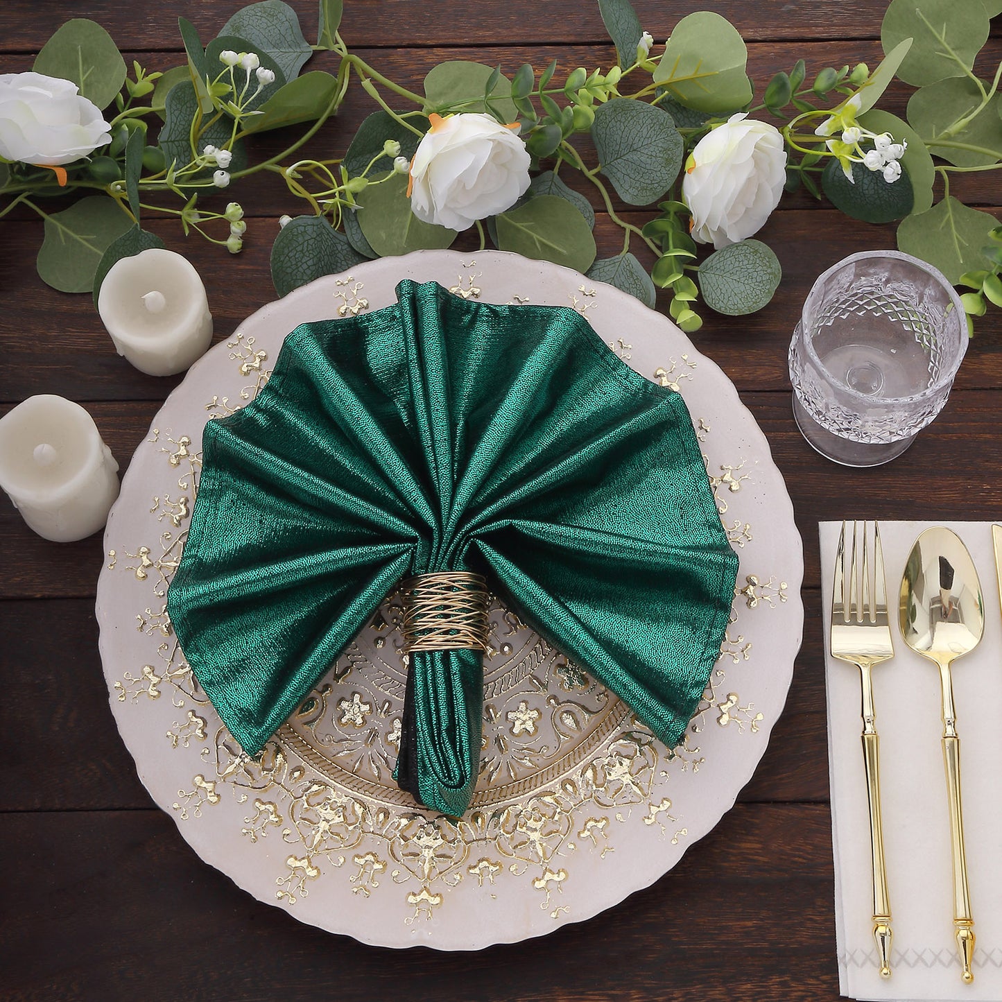 Emerald green shimmer sequin table napkin on an elegant dinner plate.