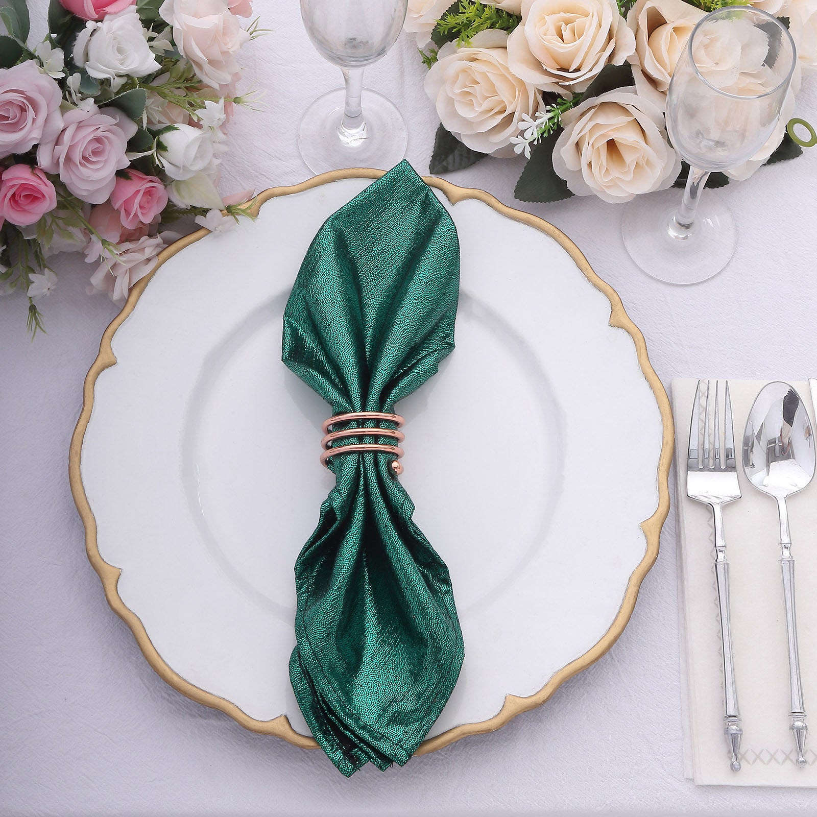 Emerald green shimmer sequin table napkin on a decorative plate.