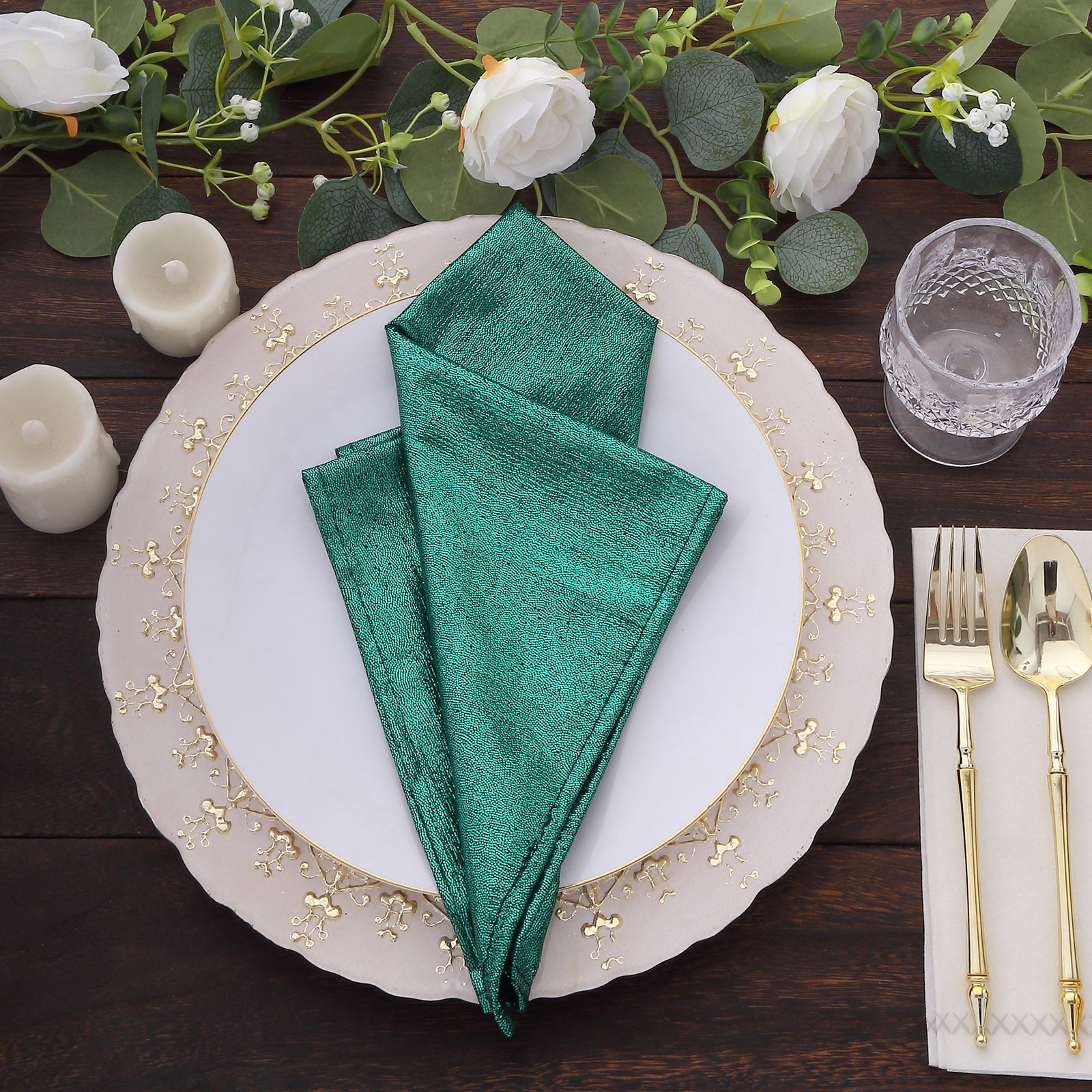 Emerald green shimmer sequin table napkins on a dining table setting.