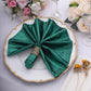 Emerald green shimmer sequin table napkin elegantly displayed on a dinner plate.