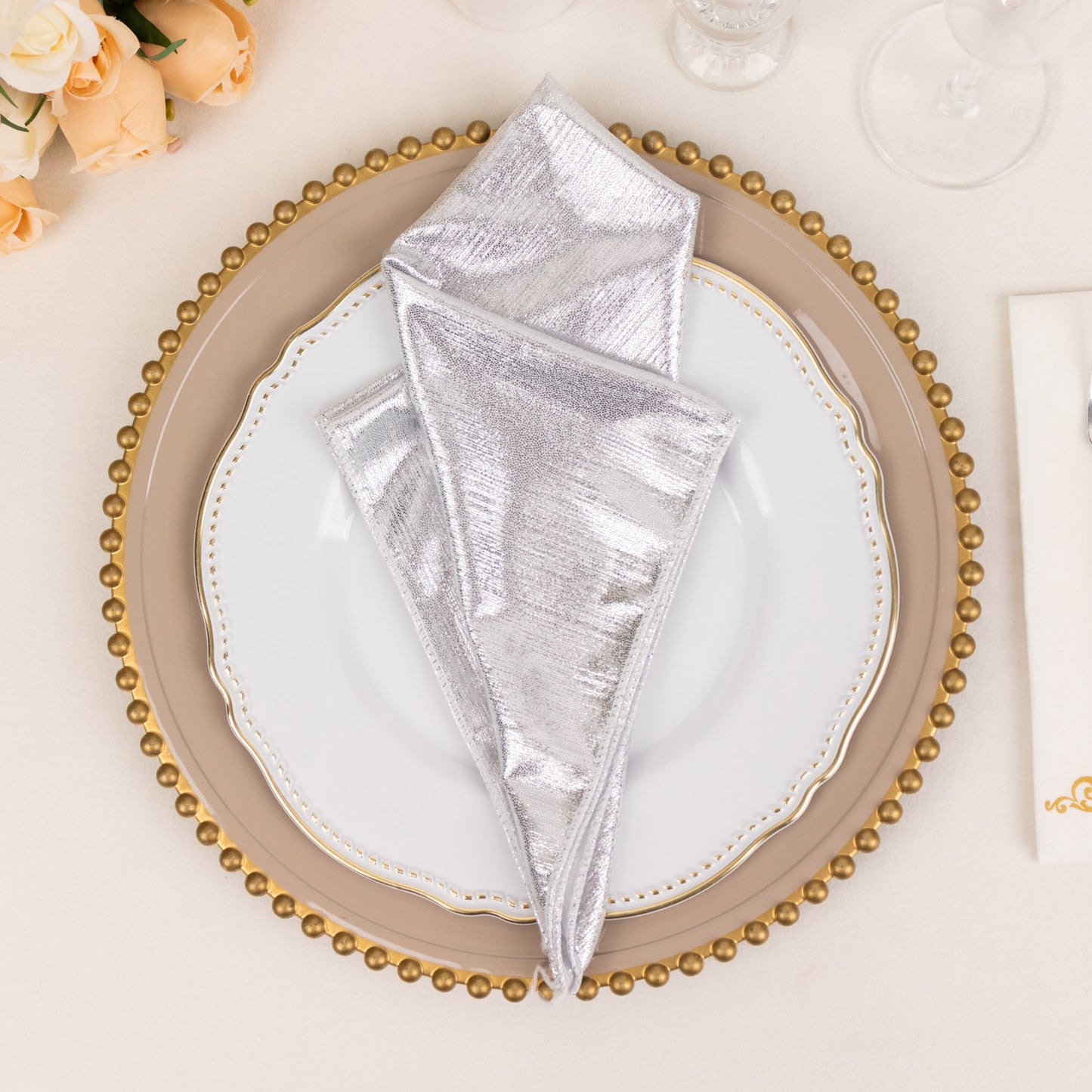 Silver shimmer sequin cloth napkins on a dinner plate.