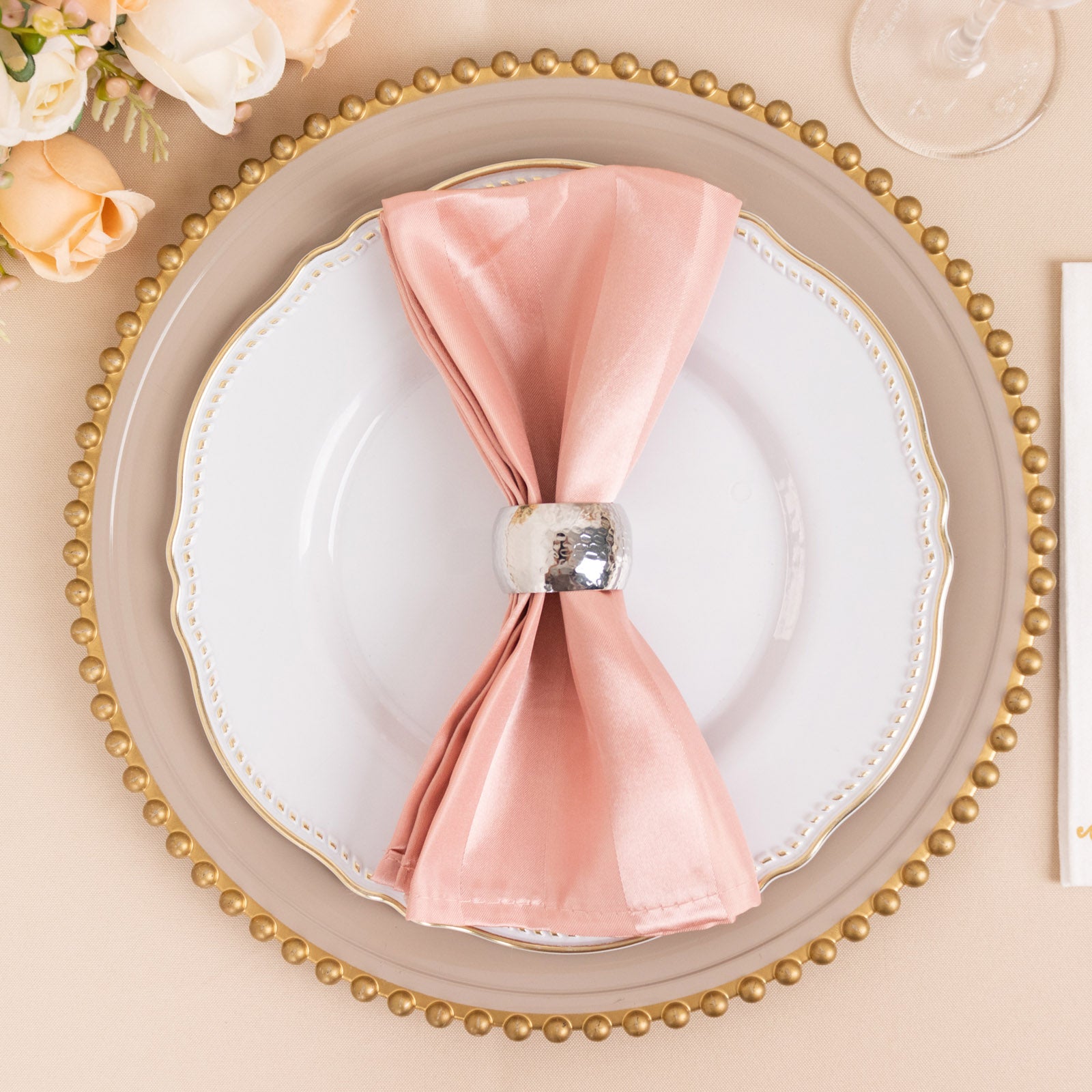 Dusty rose satin napkin elegantly displayed on a plate.